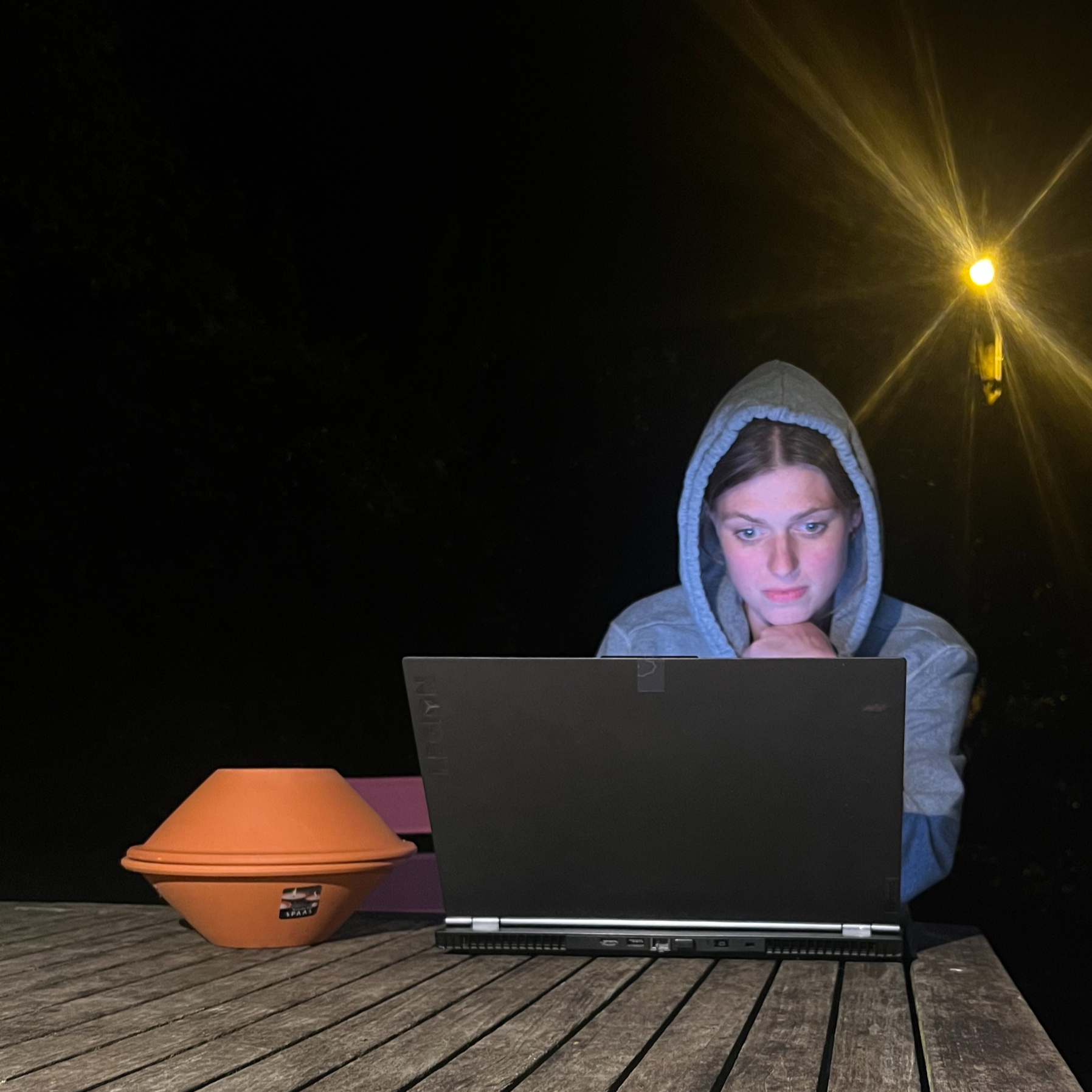 Deelnemer focust intensief op een laptop in het donker