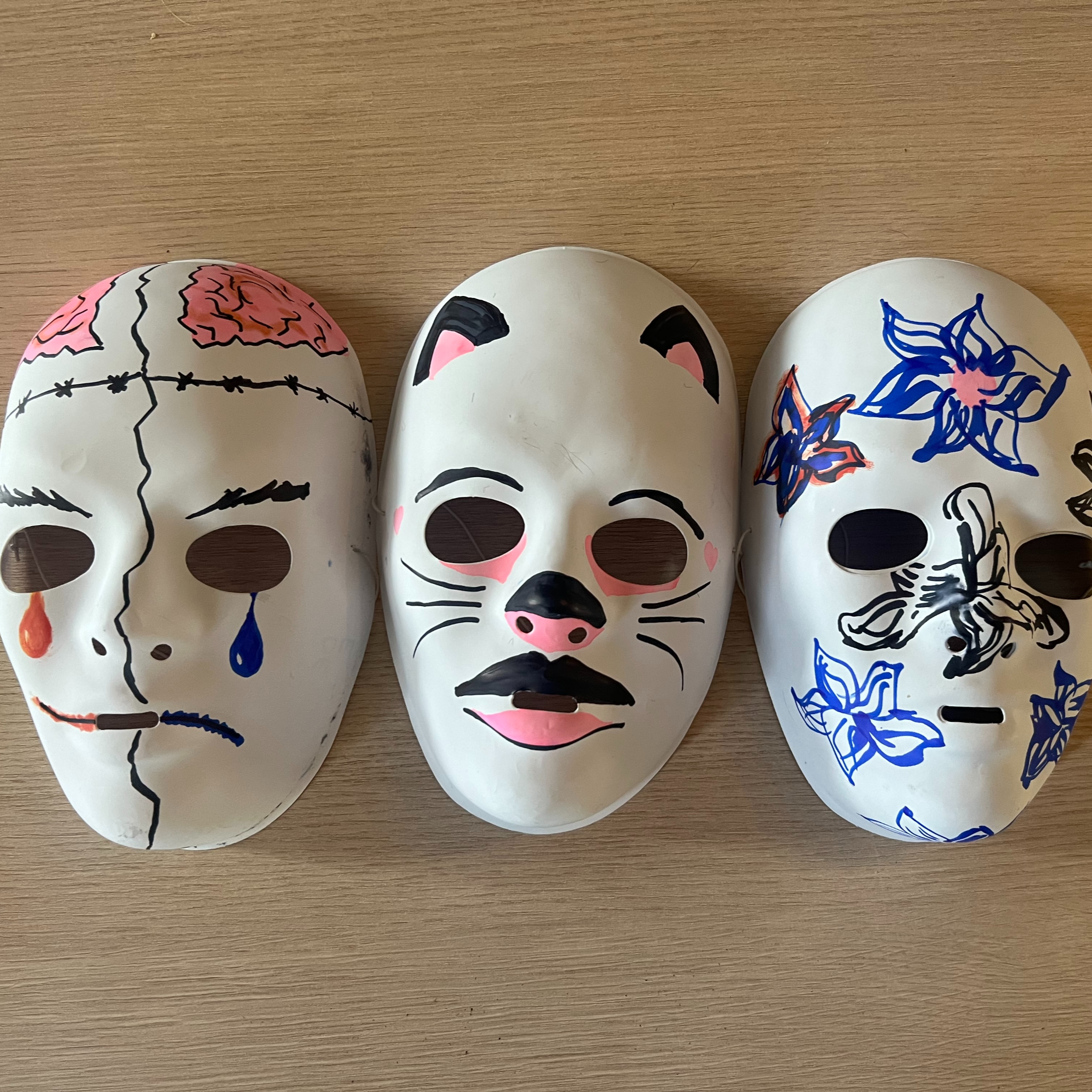 Drie beschilderde maskers als speelattributen